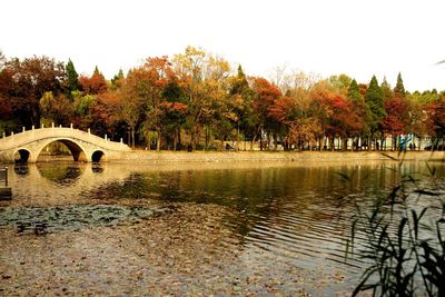 Bridge over river against sky during autumn