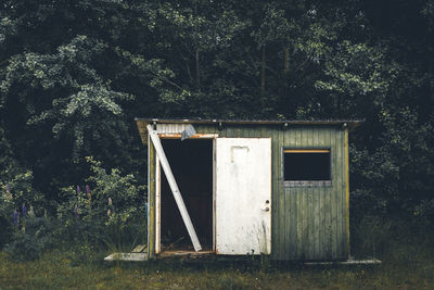 Abandoned old hut or cabin. dark forest in the background. 