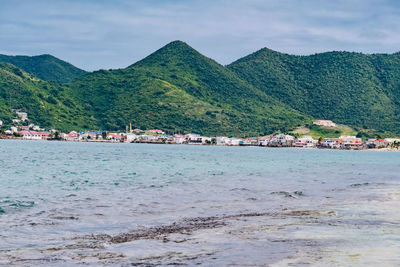 Scenic view of sea and mountains against sky