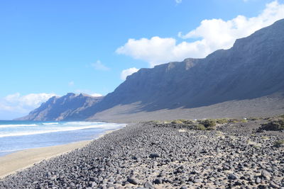 Scenic view of sea and mountains against sky