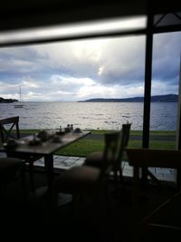 Empty chairs and tables at seaside