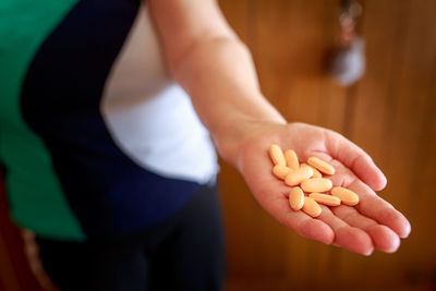 Midsection of man holding pills