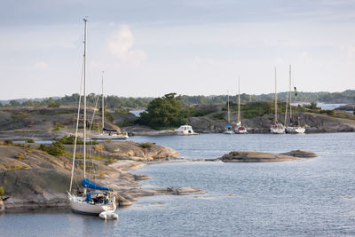 Yachts moored at rocky coast