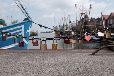 Love locks hanging on chain at harbor