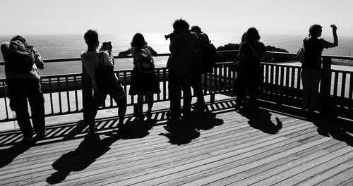 Man standing on pier at sea