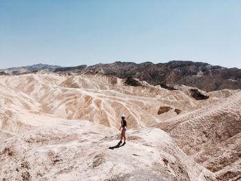 Full length of woman on arid landscape against sky