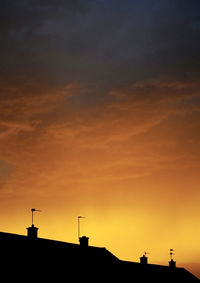 Low angle view of silhouette buildings against sky at sunset