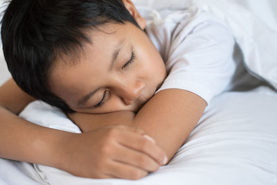 Close-up of baby sleeping on bed