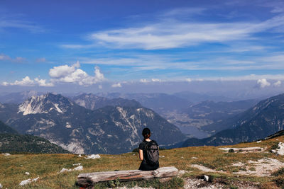 Rear view of woman looking at mountain against sky