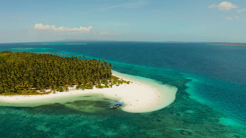 Tropical island with sandy beach by atoll with coral reef and blue sea. patongong island