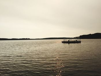 Boat sailing in lake against sky