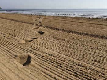 High angle view of footprints on sandy beach