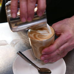 Midsection of man holding coffee cup on table