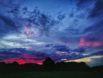 Scenic view of dramatic sky over silhouette landscape