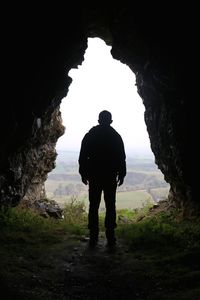 Silhouette of man standing in cave