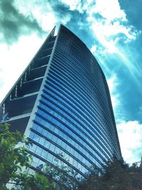 Low angle view of modern building against cloudy sky