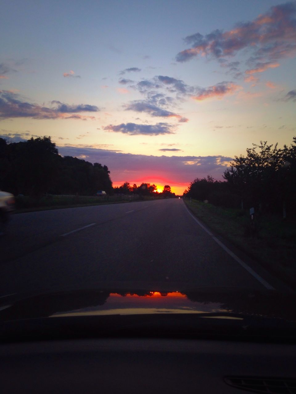 transportation, sunset, road, sky, the way forward, car, road marking, cloud - sky, orange color, land vehicle, diminishing perspective, tree, silhouette, street, country road, mode of transport, scenics, beauty in nature, vanishing point, tranquil scene