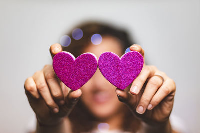 Close-up of woman holding heart shaped hand