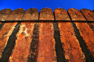 Old weathered fortified walls of jaigarh fort against clear sky