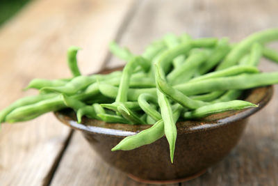 Close-up of green chili peppers on wood