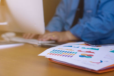 Close-up of man using laptop on table