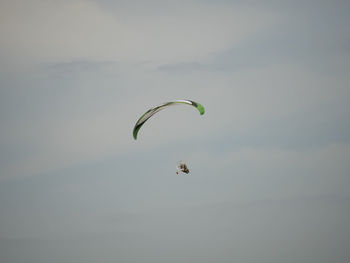 Low angle view of enjoying person powered parachute against sky