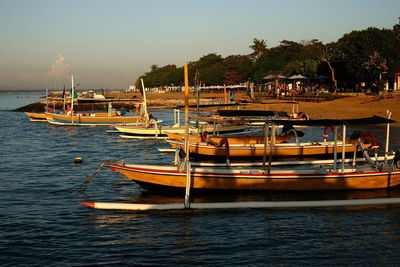 Boats moored in sea against clear sky