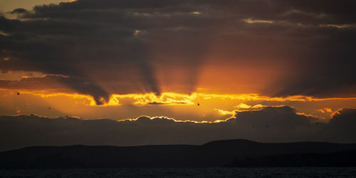 Scenic view of dramatic sky over sea during sunset