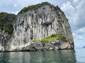 Rock formations by sea against sky