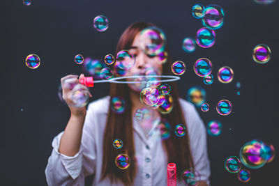 Woman blowing bubbles in city
