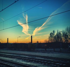 Railroad tracks against sky during sunset