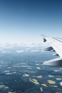 Airplane flying over landscape against sky