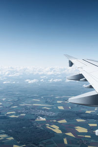 Airplane flying over landscape against sky