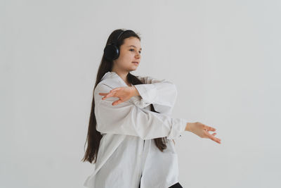 Portrait of young woman standing against white background
