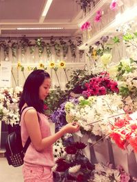 Young woman with flowers in store