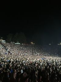 Group of people watching firework display at night