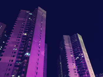 Low angle view of illuminated buildings against sky at night
