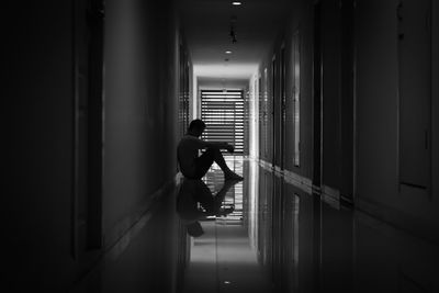 Rear view of man walking in corridor of building