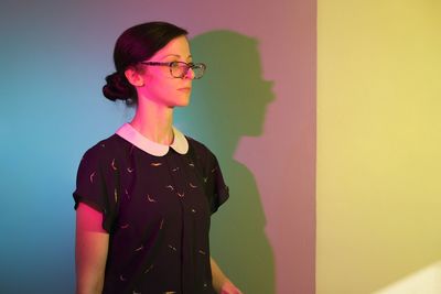 Young woman standing against wall