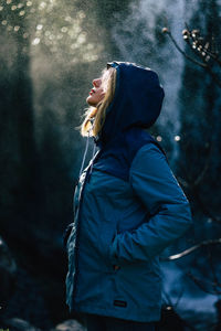 Side view of young woman looking at winter