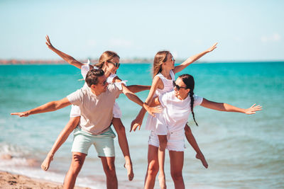 Low angle view of people at beach against sky