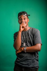 Young man standing against blue background