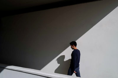 Side  view of man walking against wall