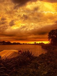 Scenic view of dramatic sky over field during sunset