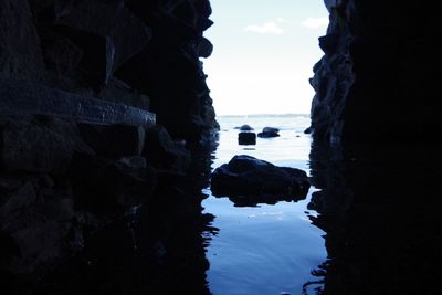 Rock formation on beach against sky