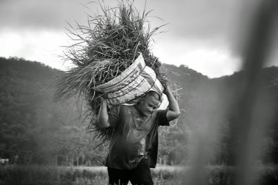 Full length of woman standing on field against sky