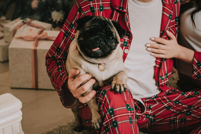 Midsection of man holding small dog