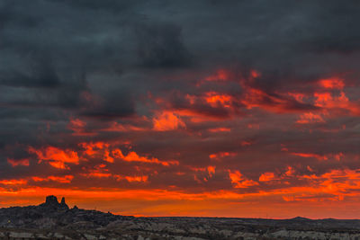 Scenic view of dramatic sky over silhouette landscape