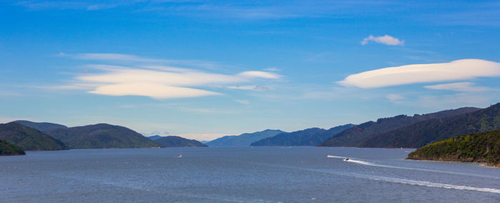 Scenic view of sea and mountains against sky