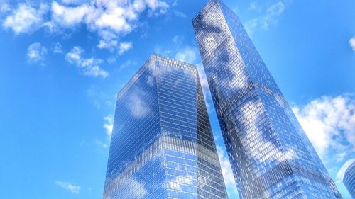 Low angle view of skyscraper against cloudy sky